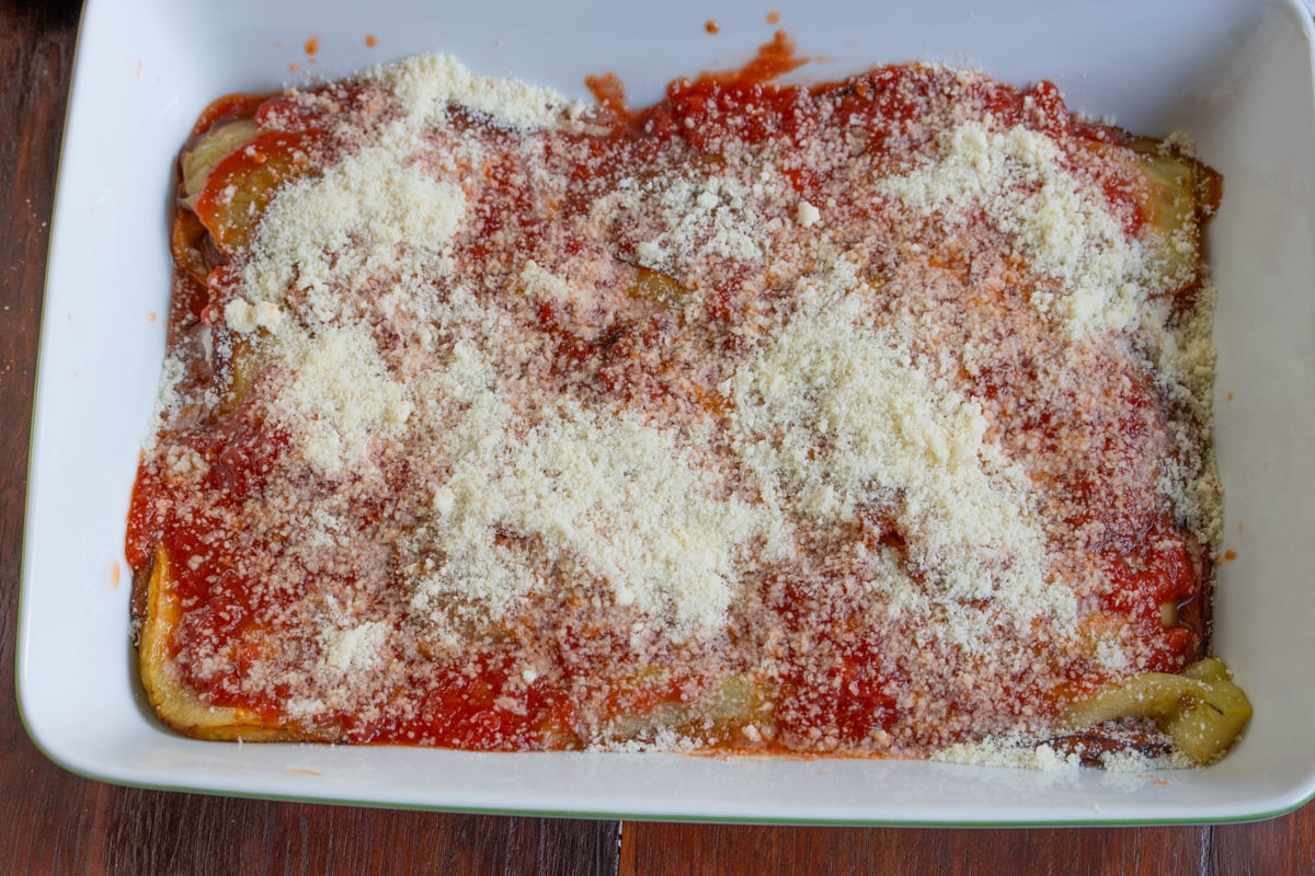 layering the eggplant with the tomatoes and mozzarella